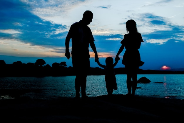 Famiglia felice in riva al mare sulla silhouette della natura