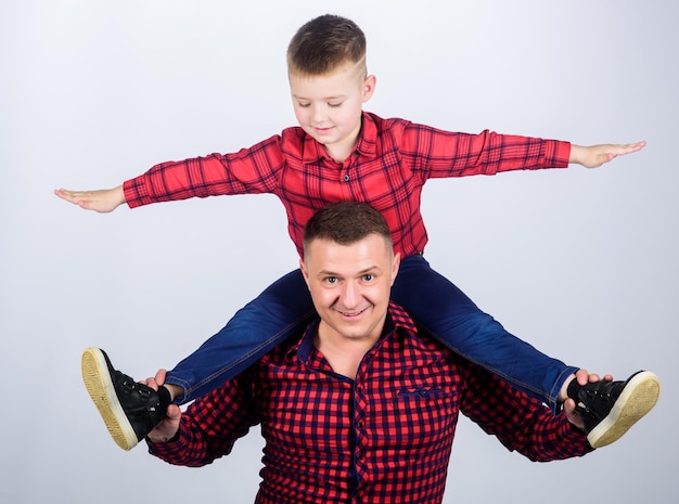 Famiglia felice insieme piccolo ragazzo con papà uomo festa del papà Godersi il tempo insieme infanzia genitorialità padre e figlio in camicia a scacchi rossa Sviluppo di una nuova linea di moda senso di libertà