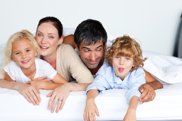 Famiglia felice insieme sul letto