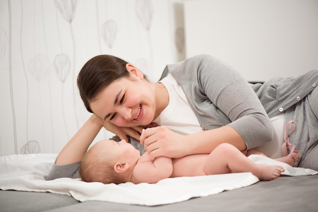 Famiglia felice. Madre che gioca con il suo bambino in camera da letto.