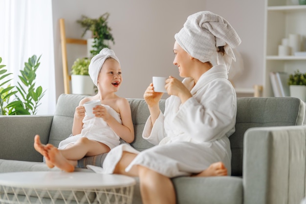 Famiglia felice Madre e figlia bambina stanno bevendo il tè dopo un bagno