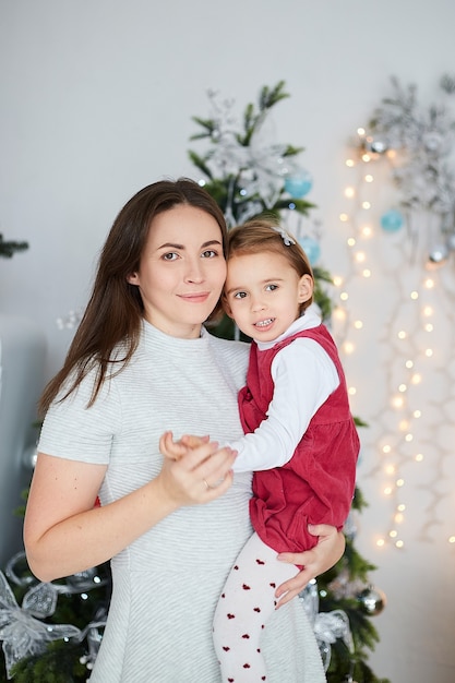 Famiglia felice madre e figlia vicino a un albero di Natale