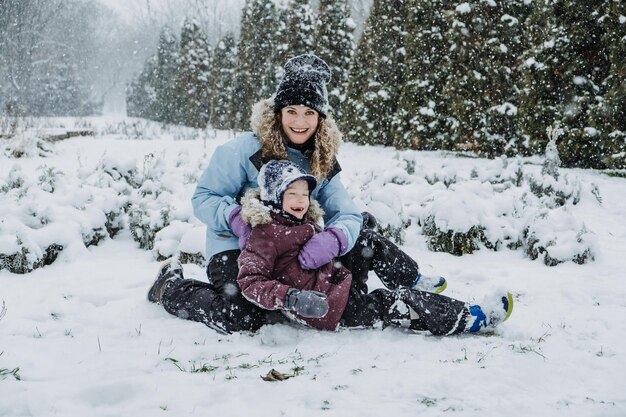 Famiglia felice madre e figlio che si divertono all'aperto in inverno natura nevosa sfondo mamma e bambino