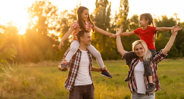 Famiglia felice: madre padre e figlia bambino sulla natura sul tramonto