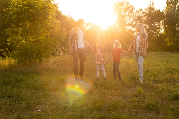 Famiglia felice: madre padre e figlia bambino sulla natura sul tramonto