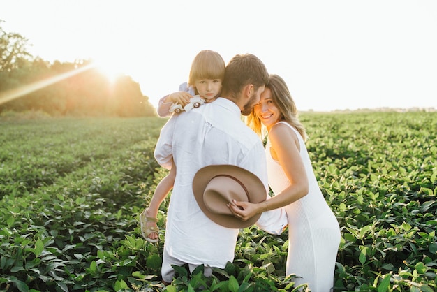 Famiglia felice madre padre e figlia figlia sulla natura al tramonto