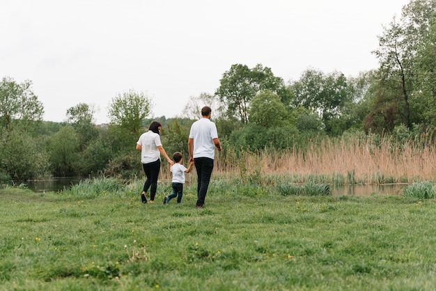 Famiglia felice madre padre e figlio figlio sulla natura sul tramonto.