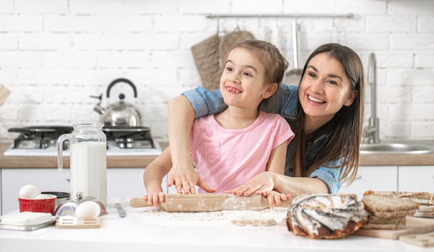 Famiglia felice. Mamma e figlia preparano i pasticcini in cucina.