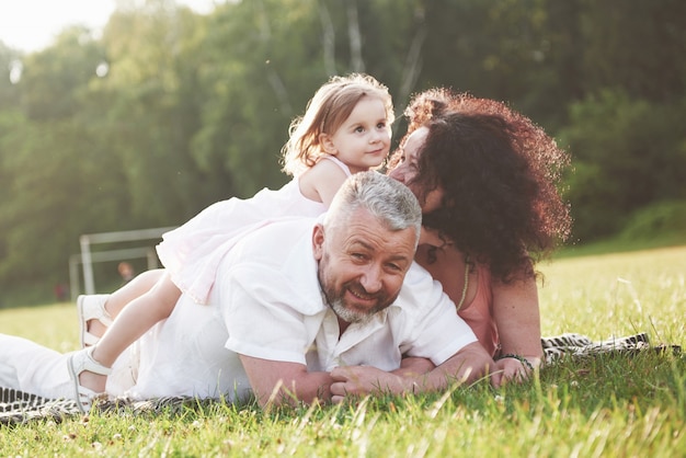 Famiglia felice, padre della madre e figlia del bambino nella natura al tramonto