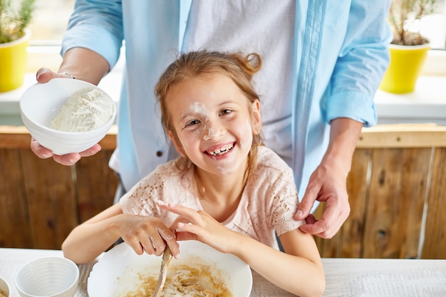 Famiglia felice, padre e figlia che preparano insieme pasta in cucina