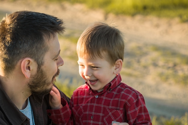 Famiglia felice. Padre e figlio che giocano e abbracciano la vita all'aria aperta. Festa del papà