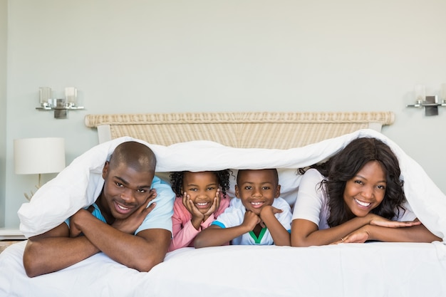 Famiglia felice sdraiata sul letto