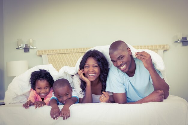 Famiglia felice sdraiata sul letto