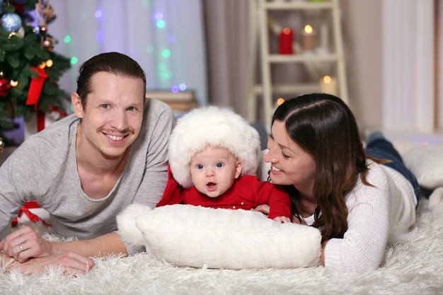 Famiglia felice sdraiata sul pavimento nella stanza di Natale decorata