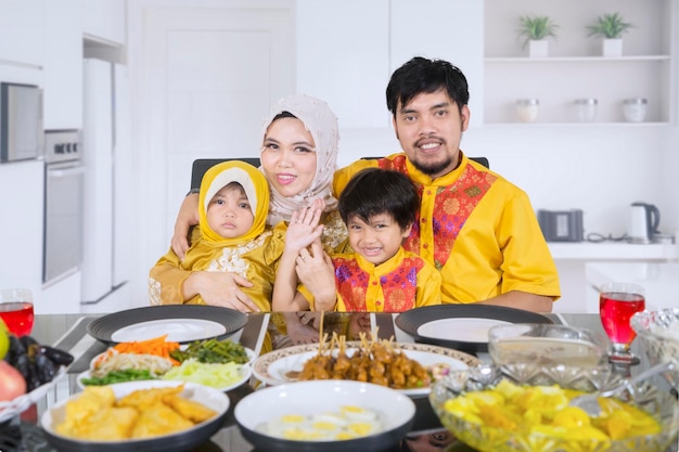 Famiglia felice seduta vicino al tavolo da pranzo