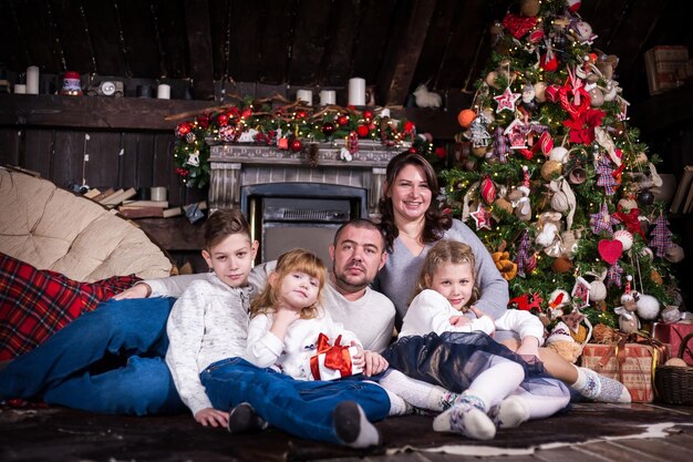 Famiglia felice sorridente con doni in una stanza a Natale