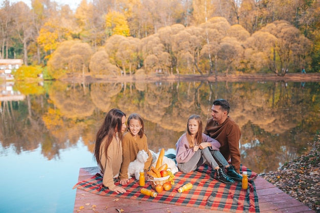 Famiglia felice su un picnic nel parco in autunno