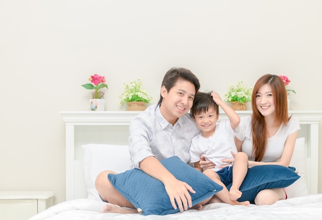 Famiglia felice sul letto in camera da letto