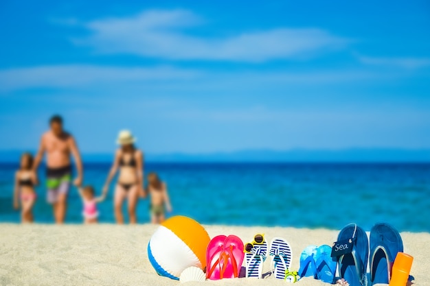 Famiglia felice sul mare con pantofole sulla natura