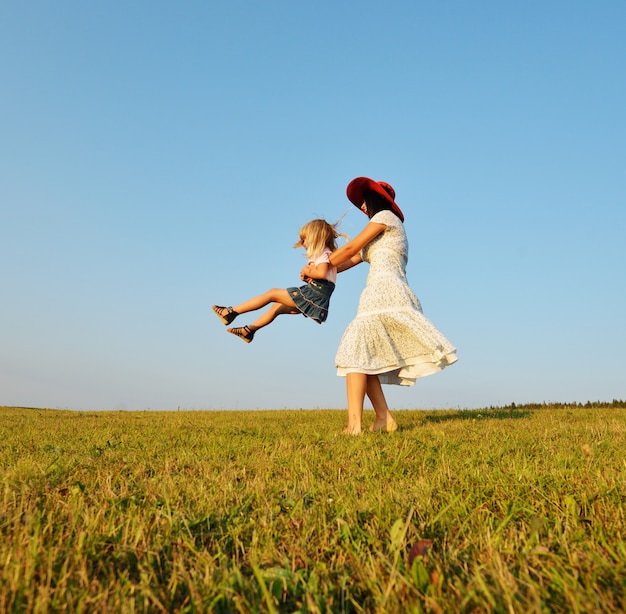 Famiglia felice sul prato bella estate avendo circlin tempo felice intorno