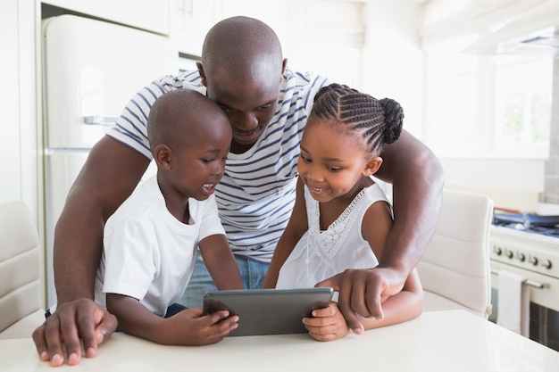 Famiglia felice sul tavolo con tavoletta digitale