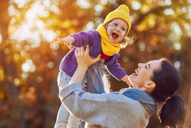 Famiglia felice sulla passeggiata autunnale! Madre e figlia che camminano nel parco e si godono la bellissima natura autunnale.