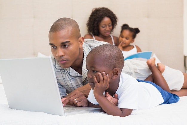 Famiglia felice trascorrere del tempo insieme sul letto