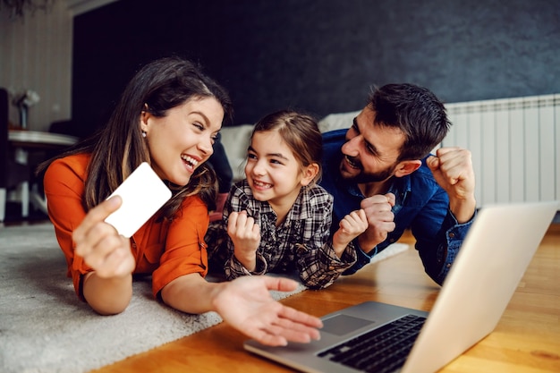 Famiglia felice utilizzando laptop per lo shopping online.