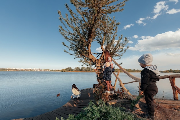 Famiglia felice vicino al fiume il giorno di primavera. Il concetto di ricreazione attiva della famiglia estiva