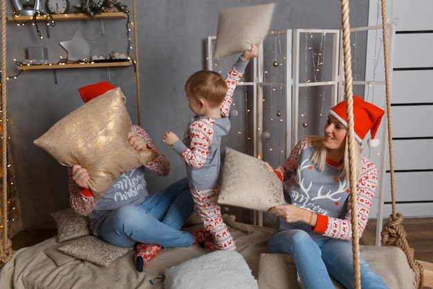 Famiglia felice vicino all'albero di Natale in camera da letto.