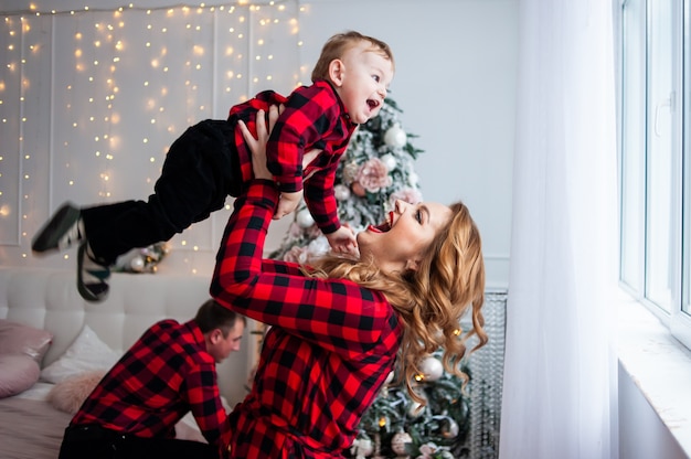 Famiglia felice vicino all'albero di Natale in interni accoglienti