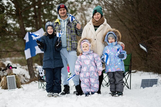 Famiglia finlandese con bandiere finlandesi in una bella giornata invernale Gente scandinava nordica