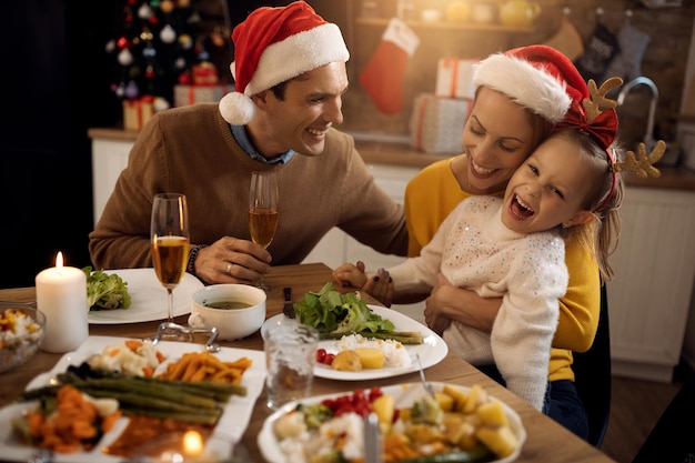 Famiglia gioiosa godendo al tavolo da pranzo il giorno di Natale