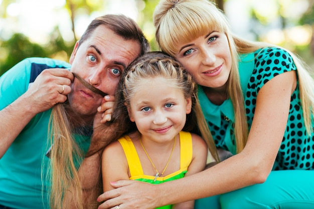 Famiglia giovane e bella nel parco. Madre, padre e figlia