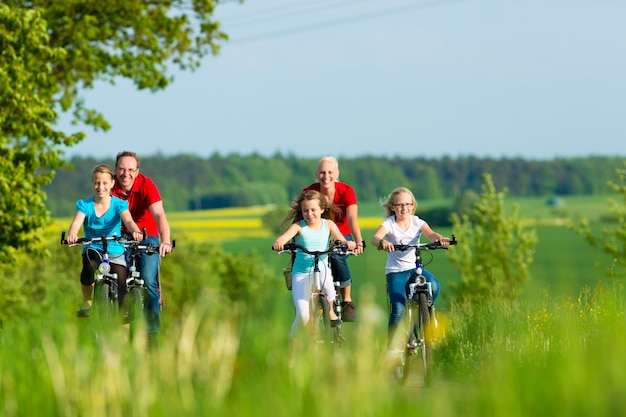 Famiglia in bicicletta all'aperto in estate