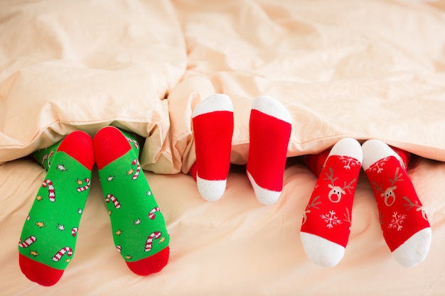 Famiglia in calze di Natale sdraiata sul letto