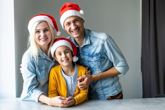 Famiglia in cappelli di Babbo Natale a casa. Concetto di Natale e Capodanno per le vacanze invernali