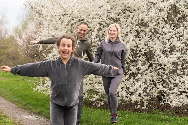 Famiglia in giardino fiorito con alberi.