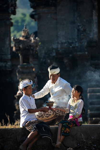 Famiglia indonesiana in abiti tradizionali sullo sfondo del tempio.