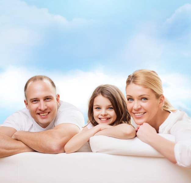 famiglia, infanzia e persone - madre sorridente, padre e bambina su sfondo blu cielo