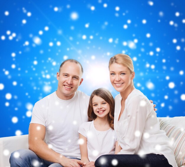 famiglia, infanzia, vacanze di Natale e persone - madre, padre e bambina sorridenti su sfondo blu innevato