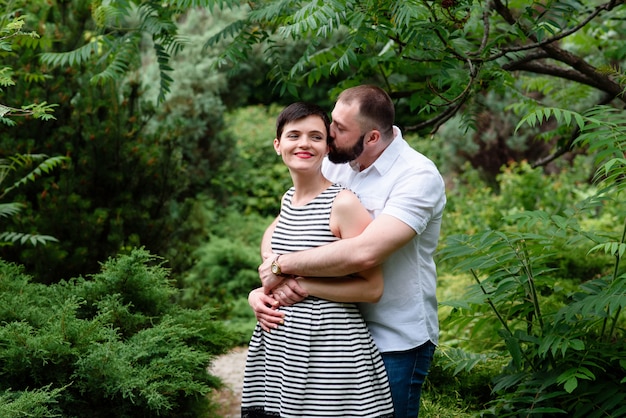 Famiglia insieme nel parco estivo all&#39;aperto. La donna è incinta