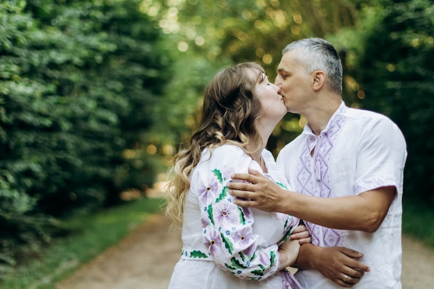 Famiglia insieme nel parco estivo. La donna è incinta