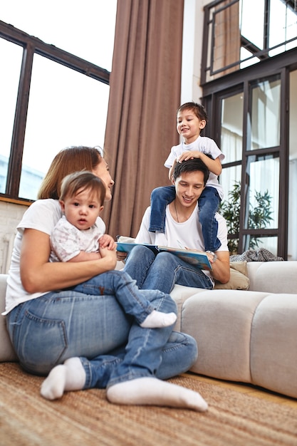 Famiglia internazionale a casa sul divano, abbracciati e goditi la vita. Felice vita familiare.