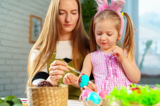 Famiglia, madre e figlia sveglie che preparano per la celebrazione di Pasqua