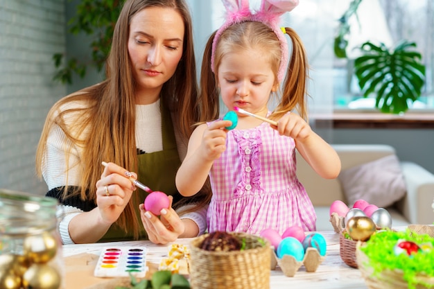 Famiglia, madre e figlia sveglie che preparano per la celebrazione di Pasqua