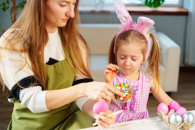 Famiglia, madre e figlia sveglie che preparano per la celebrazione di Pasqua