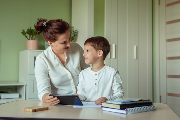 famiglia mamma e figlio facendo i compiti con gioia nella stanza facendo uso della compressa