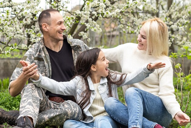 famiglia militare felice che si rilassa nel giardino.