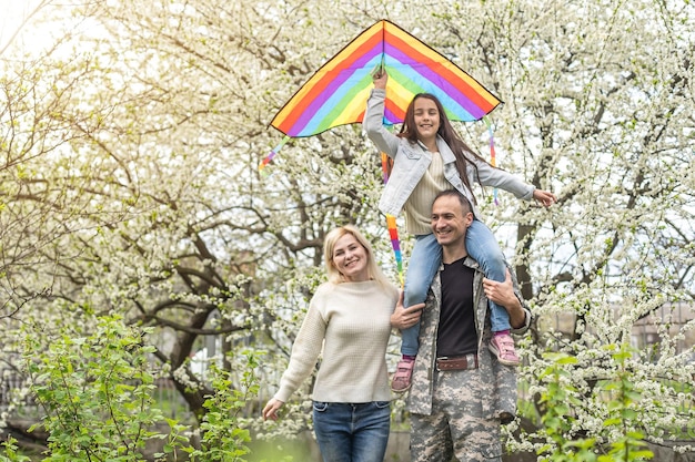 famiglia militare felice che si rilassa nel giardino.